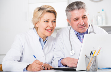 Doctor and nurse reading patient information in hospital computer database