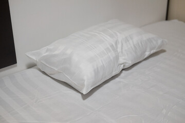 Fototapeta na wymiar Big white pillows on a white bed