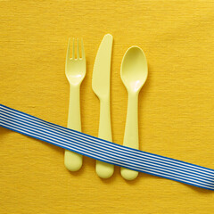 Fork knife spoon on yellow fabric background. top view, copy space