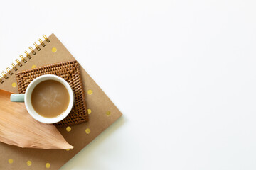 Cup of coffee and notebook on white background. Work and study place. flat lay, top view, copy space