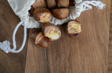Fototapeta na wymiar Bunch of roasted chestnuts inside white sackcloth