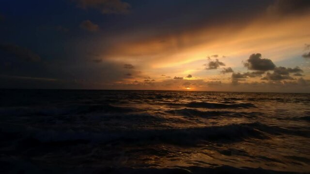 Gorgeous tilt up shot of a golden vibrant sunrise at the beach in the tropical Joao Pessoa, Brazil