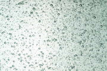 small air bubble free floating in clear liquids with light in background