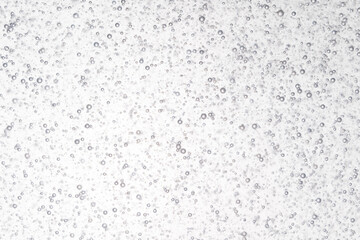 small air bubble free floating in clear liquids with light in background