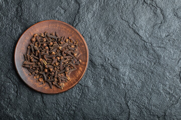 A brown plate full of dried cloves