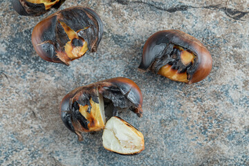 Delicious fried chestnuts on a gray background