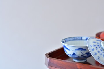 picture rice bowl. put on a Japanese lacquer serving tray. This is a very fine example of Japanese traditional antique “ imari ware ”. blurred background soft focus image. 日長風暖 柳青々 北雁帰 飛入窅冥・賈至