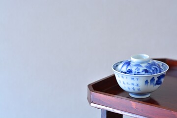 picture rice bowl. put on a Japanese lacquer serving tray. This is a very fine example of Japanese traditional antique “ imari ware ”. blurred background soft focus image. 日長風暖 柳青々 北雁帰 飛入窅冥・賈至