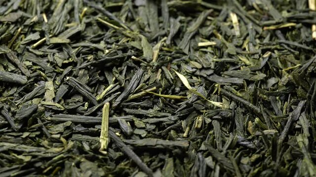 Close-up video of slowly rotating green tea leaves