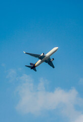 Fototapeta na wymiar Airplane in the air with blue sky and clouds. Avion en el aire con el cielo azul y nubes.