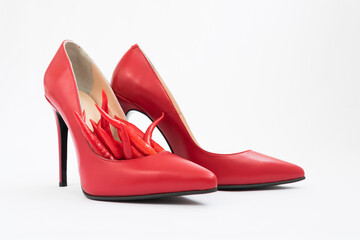 Bright red women's stiletto heels. There are chili peppers nearby. Nice combination of shoes and...