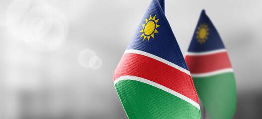 Small national flags of the Namibia on a light blurry background