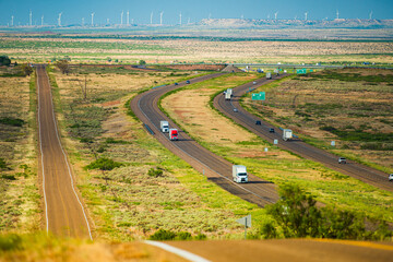 Classic view of highway road running through the barren scenery of the American Southwest with extreme heat haze. Hot sunny day with blue sky in summer.