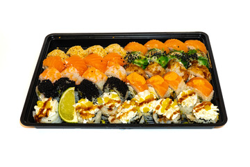 Sushi set with rolls philadelphia, california, bonito, tuna, sesame, black tobico, chuka salad, prawns and cream cheese lie in black box for delivery. Japan kitchen, european sushi rolls