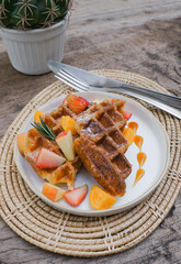 Fresh homemade waffles with blueberries and Strawberry for breakfast on wooden background.
