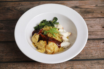 Shrimp dumpling noodles and crab meat on wood background