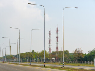 communication transmission towers by street view over sunny blue sky the digital telecom and ...