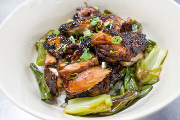 grilled chicken thighs and bowl of rice over plate.
