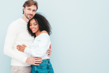 Smiling beautiful woman and her handsome boyfriend. Happy cheerful multiracial family having tender moments on grey background  in studio. Multiethnic models hugging. Embracing each other.Love concept