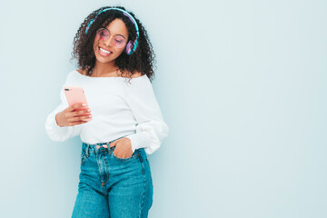 Beautiful black woman with afro curls hairstyle.Smiling model in sweater and jeans.Sexy carefree...