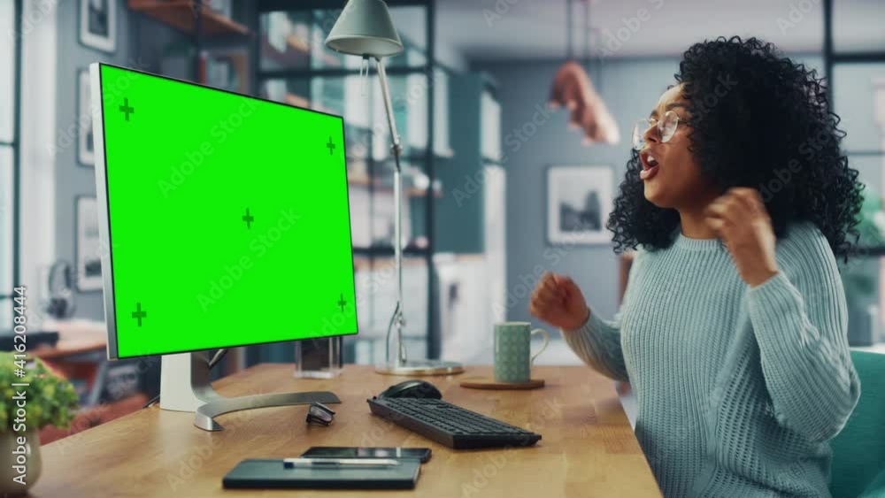 Poster latina female specialist dancing while sitting next to desktop computer with green screen mock up di
