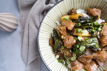 grilled chicken thighs and bowl of rice over plate.