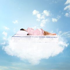 Young woman sleeping on mattress soft as clouds in blue sky