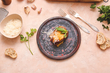 Plate of tasty baked eggplant with cheese on color background