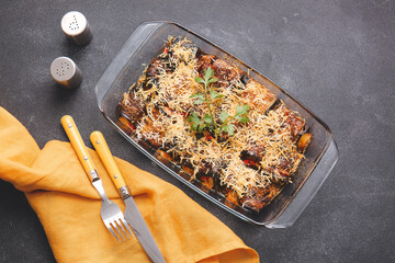Dish of tasty baked eggplant on dark background
