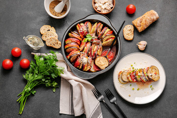 Dish of tasty baked eggplant and tomatoes on dark background