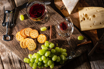 Tasting cheese platter with grapes and fruits on an old wooden table. Food for wine and romantic, cheese delicacies. Menu design horizontally. View from above.