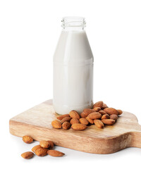 Board with bottle of tasty almond milk on white background