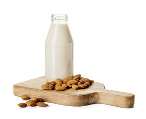 Board with bottle of tasty almond milk on white background