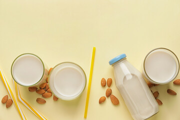 Obraz na płótnie Canvas Bottle and glasses of tasty almond milk on color background