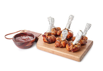 Board with tasty chicken lollipops and sauce on white background