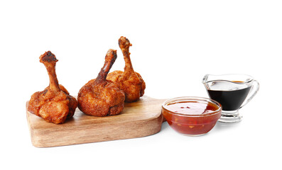Board with tasty chicken lollipops and sauce on white background