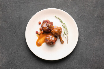Plate with tasty chicken lollipops on dark background