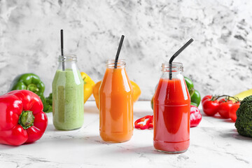 Fototapeta na wymiar Bottles of healthy smoothie with different vegetables on light background