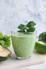 Glass of healthy smoothie with avocado and bell pepper on light background