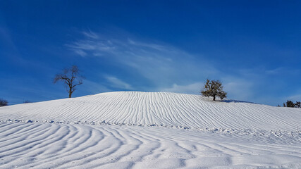 Winterlandschaft mit ausgeprägten Wasserrillen im Schnee