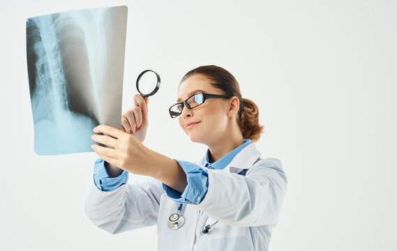 Doctor woman with magnifying glass and chest x-ray in hand
