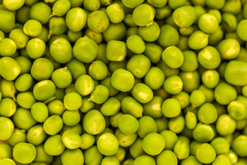A scattering of fresh green peas from above, background