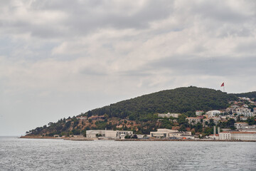 Fototapeta na wymiar Island shoreline with buildings and trees view from water