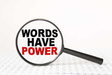 words WORDS HAVE POWER in a magnifying glass on a white background. business concept