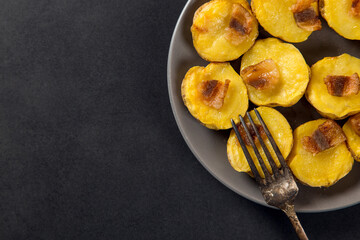 Baked potatoes with lard, a strata-fast delicious lunch, in a plate on a stone table. Copy space.