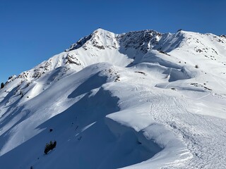 Fototapeta na wymiar Arbeser mit Gipfelkreuz beim Skigebiet Kellerjoch am Hecher Pillberg in der Nähe von Schwaz Wattens Innsbruck in Tirol, gegenüber das Karwendel Gebirge im Winter mit Schneeschuhen oder Tourenski