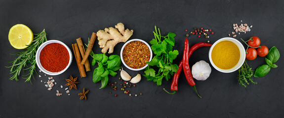 Colorful various herbs and spices for cooking on dark background