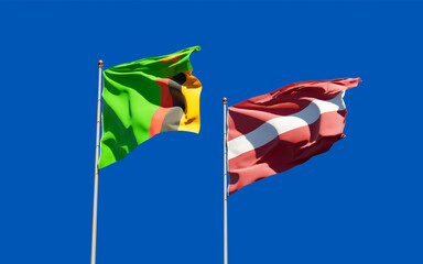 Flags of Zambia and Latvia waving together.