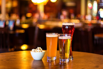Glasses of different types of beer on a wooden table