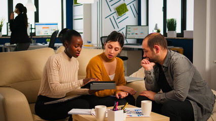 Diverse colleagues during business meeting with african american woman manager brainstorming company development plan. Employees in modern start up office discussing project strategy sharing ideas